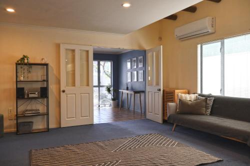 a living room with a couch and a table at The Blue Jem - A central city home away from home! in Napier