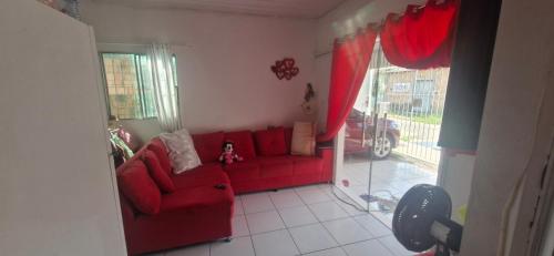 a red couch in a living room with a window at R&D eventos in Marituba