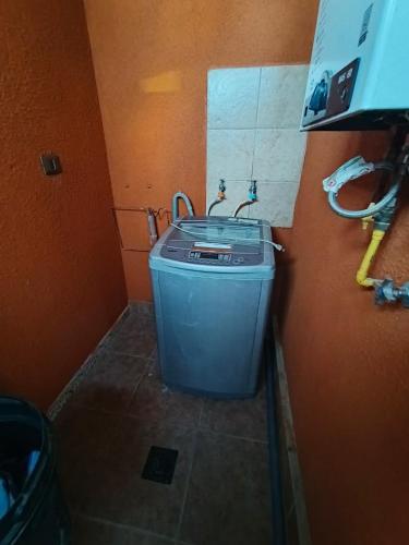 a bathroom with a trash can in the corner of a room at Casa privada en condominio in Calama