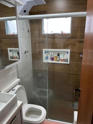 a bathroom with a shower with a toilet and a sink at Casa de Verão in Florianópolis