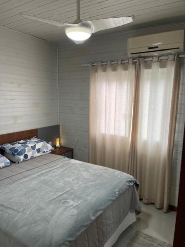 a bedroom with a bed and a ceiling fan at Casa de Verão in Florianópolis