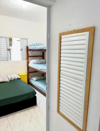 une chambre avec un miroir et une chambre avec des lits superposés dans l'établissement Casa Beira Mar - Vista do Mar pela Janela da Sala, perfeita, em frente à praia da enseada Sesc Bertioga, à Bertioga