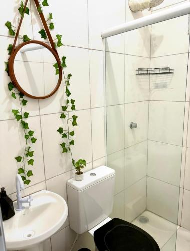 une salle de bains blanche avec toilettes et lavabo dans l'établissement Casa Beira Mar - Vista do Mar pela Janela da Sala, perfeita, em frente à praia da enseada Sesc Bertioga, à Bertioga