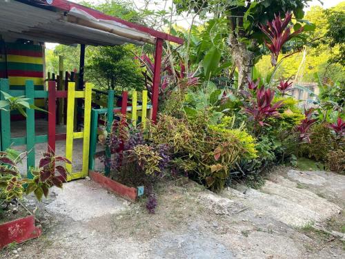 a garden with a colorful fence and some plants at Nature in portland Eco Villas in Port Antonio