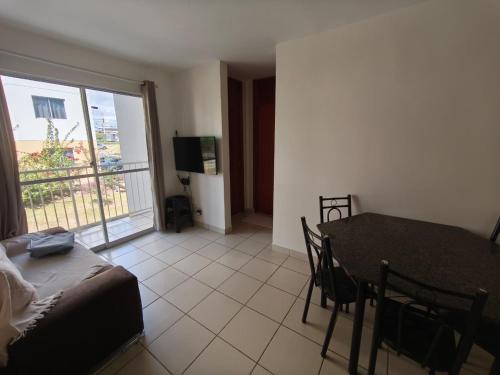 a living room with a dining room table and a balcony at Lindo e Confortavel Apto Ideal Torquato in Manaus