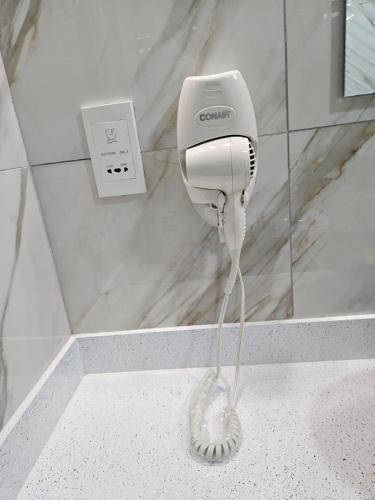 a hairdryer on a wall in a bathroom at Agape Suites-Room 3- 1st Floor in Soufrière