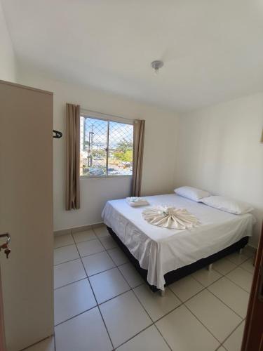 a bedroom with a large bed with a window at Lindo e Confortavel Apto Ideal Torquato in Manaus