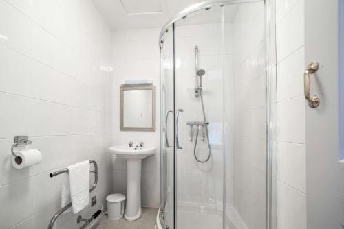 une salle de bain blanche avec une douche et un lavabo dans l'établissement Comfort Inn Blackpool Gresham, à Blackpool