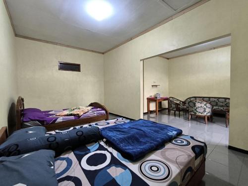 a bedroom with two beds and a table and chairs at Tengger Bromo Villa in Ngadisari