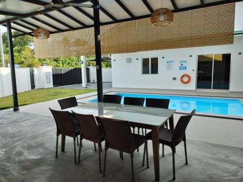 a table and chairs and a swimming pool at Homestay 229 Private Pool behind PD Ostrich Farm in Port Dickson
