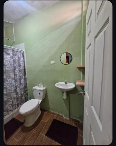 a bathroom with a toilet and a sink at Yaxlik River Lodge in Lanquín