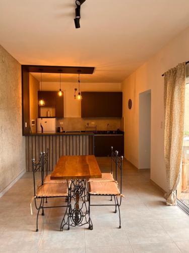 - une salle à manger et une cuisine avec une table et des chaises en bois dans l'établissement Casa Las Breas del Champaquí, à Las Tapias