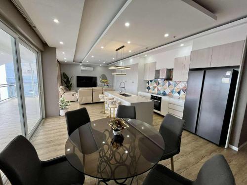 a kitchen and dining room with a glass table and chairs at Chequers Suites Subic Bay in Olongapo