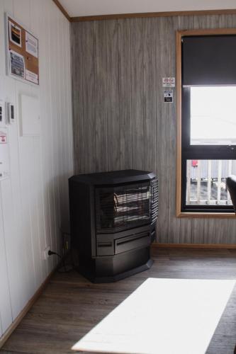 a living room with a television and a stove at Mount Rumney Escapes Seaview House 1 - Possum House in Mount Rumney