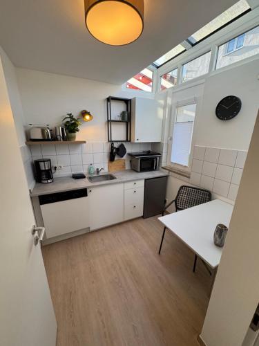 a small kitchen with white cabinets and a table at Gästeapartment am Agra Park 