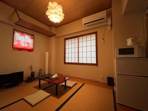 un salon avec une table et un réfrigérateur dans l'établissement EX21 和モダン 畳部屋 駅から歩いて6分 最大3人 Japanese Modern Tatami Room 6Minute Walk from Station Maximum 3 Guests, à Nagoya