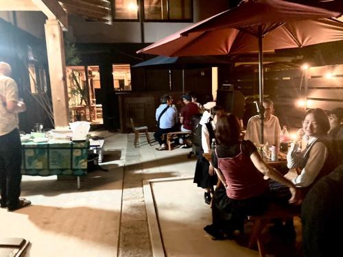 a group of people sitting at a table with an umbrella at Suehiroya - Vacation STAY 60087v in Nakatsu