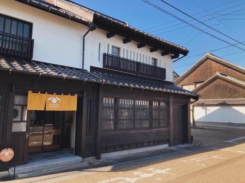 a white building with a black gate and a building at Suehiroya - Vacation STAY 60087v in Nakatsu