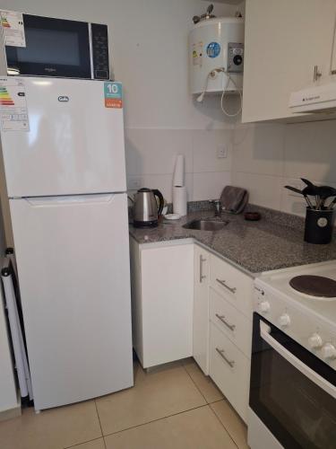 a kitchen with a white refrigerator and a sink at Excellent Monoambiente in Santos Lugares