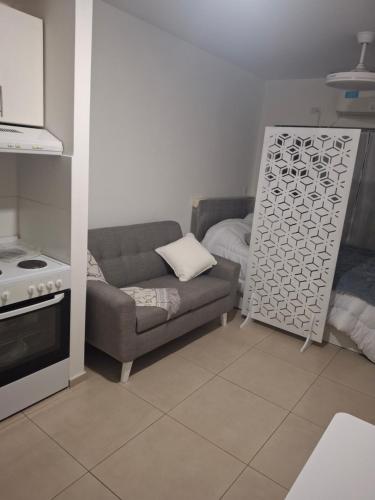 a living room with a couch and a stove at Excellent Monoambiente in Santos Lugares