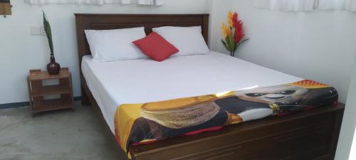 a bedroom with a bed with a blanket on it at Sun Beach Villa in Weligama