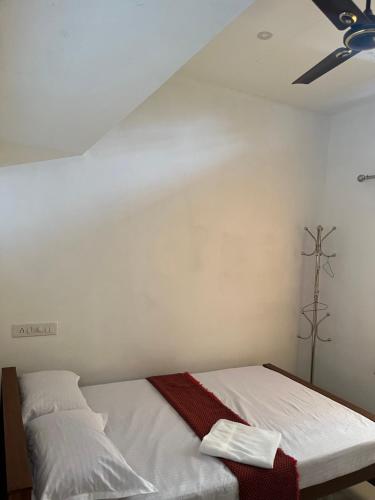 a bedroom with a bed with a ceiling fan at Green and Green in Vagamon
