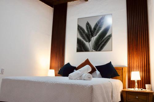 a bedroom with a white bed with two pillows at El Portal de los Pasos in Antigua Guatemala