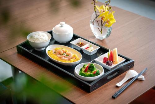 a tray with four dishes of food on a table at SSAW Boutique Hotel Foshan Qiandeng Lake in Foshan