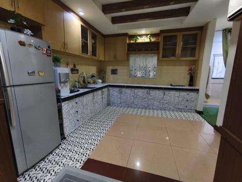a kitchen with a refrigerator and a tile floor at Ujana Kingfisher double storey 3 Bedroom - Farah Biz Homestay in Kota Kinabalu