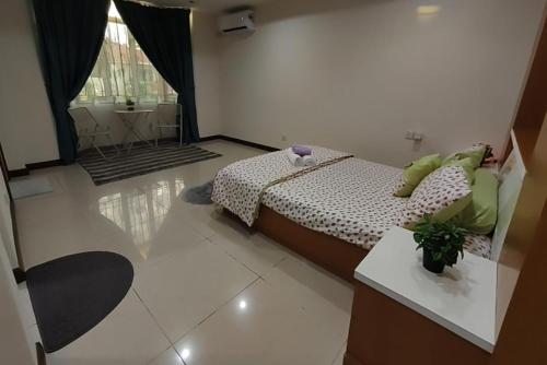 a bedroom with a bed and a table in a room at Ujana Kingfisher double storey 3 Bedroom - Farah Biz Homestay in Kota Kinabalu