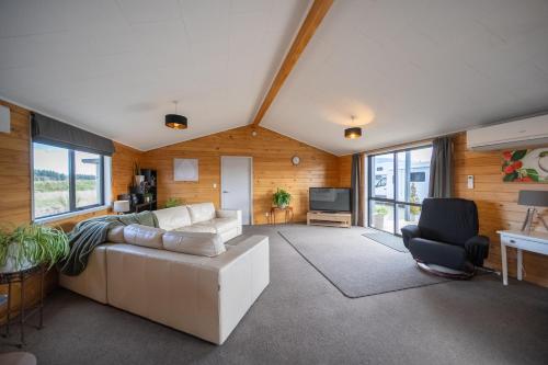 a living room with a white couch and a tv at Anderson Escape in Te Anau