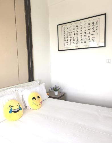 two pillows with smiley faces on them sitting on a bed at Huafu Seaview Suites in Zhuhai