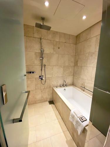 a bathroom with a bath tub and a shower at Ascott Marunouchi Tokyo in Tokyo