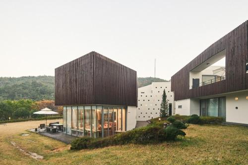 a house on a hill with a large building at Seosan Soohwarim in Okkye-ri