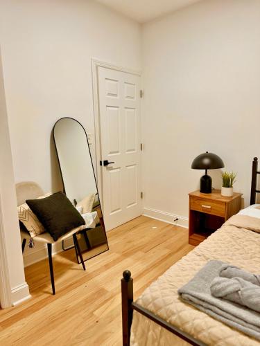 a bedroom with a mirror and a bed and a chair at Spacious 3BR Apartment - 12min Newark Airport -Near NYC & Malls in Newark