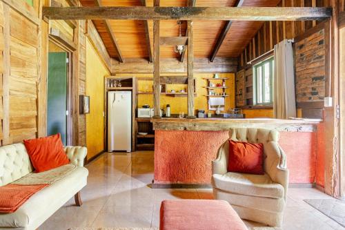 a living room with two chairs and a bar at Cabana em Urubici in Urubici