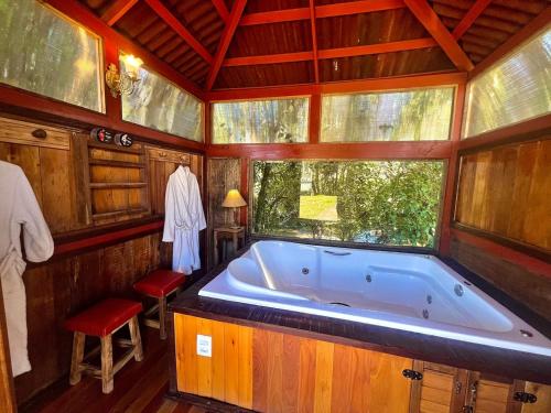 a large bath tub in a room with a window at Cabana em Urubici in Urubici
