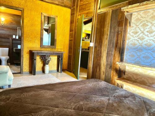 a bedroom with a bed and a table and a mirror at Cabana em Urubici in Urubici