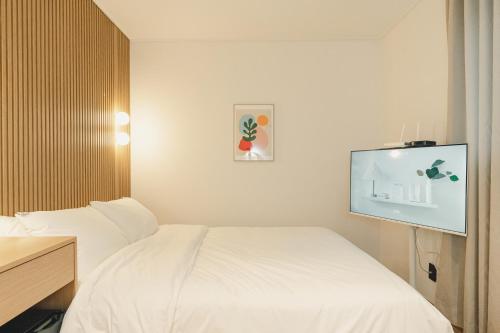 a hotel room with a bed and a flat screen tv at Hotel Daun Guri in Guri