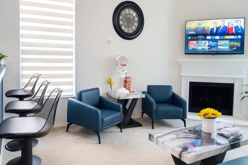 a living room with chairs and a table and a tv at Entire Home 3BR Hidden Gem Getaway with Level 2 EV Charger, Central Location in McKinney