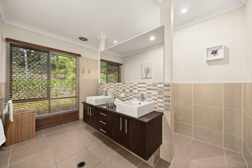 a bathroom with a sink and a mirror at Hinterland Retreat 5 bedrooms, pool & hot tub in Gold Coast