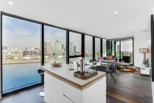 a kitchen and living room with large glass windows at Aerie Stays NewQuay Collection in Melbourne