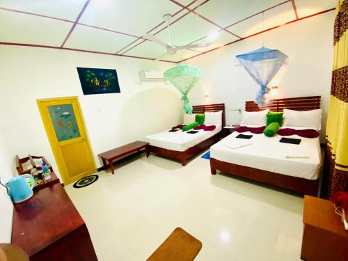a room with two beds and a table and chairs at Panoramic Royal Villa in Sigiriya