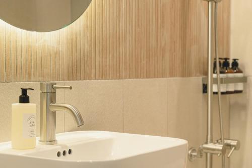 a bathroom with a white sink and a mirror at Hotel Daun Guri in Guri