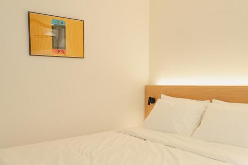 a bedroom with a bed and a picture on the wall at Hotel Daun Guri in Guri