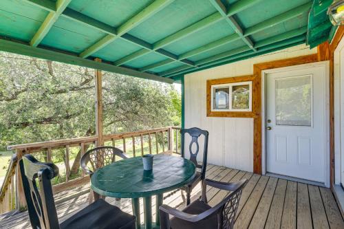 a patio with a table and chairs on a deck at 2 Mi to Fishing on Lake Whitney Cottage with Deck in Whitney
