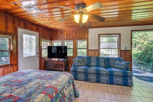 a bedroom with a bed and a couch and a ceiling fan at 2 Mi to Fishing on Lake Whitney Cottage with Deck in Whitney