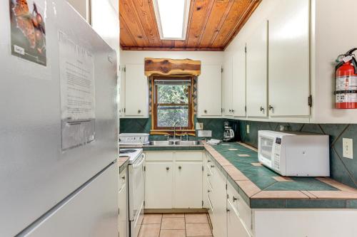 a kitchen with white cabinets and a sink and a window at 2 Mi to Fishing on Lake Whitney Cottage with Deck in Whitney