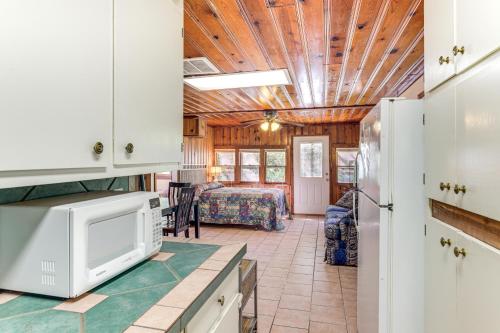 a kitchen with a microwave and a living room at 2 Mi to Fishing on Lake Whitney Cottage with Deck in Whitney