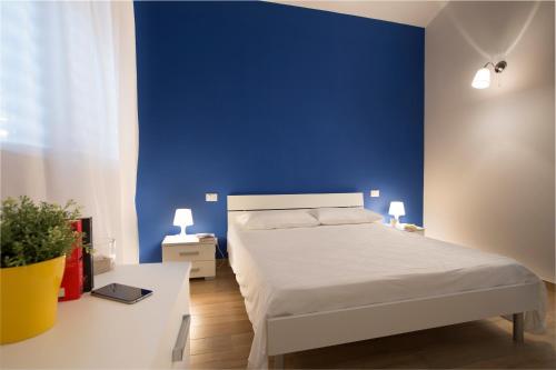 a blue bedroom with a bed and a blue wall at Holiday Home Nicola Santoro in Custonaci